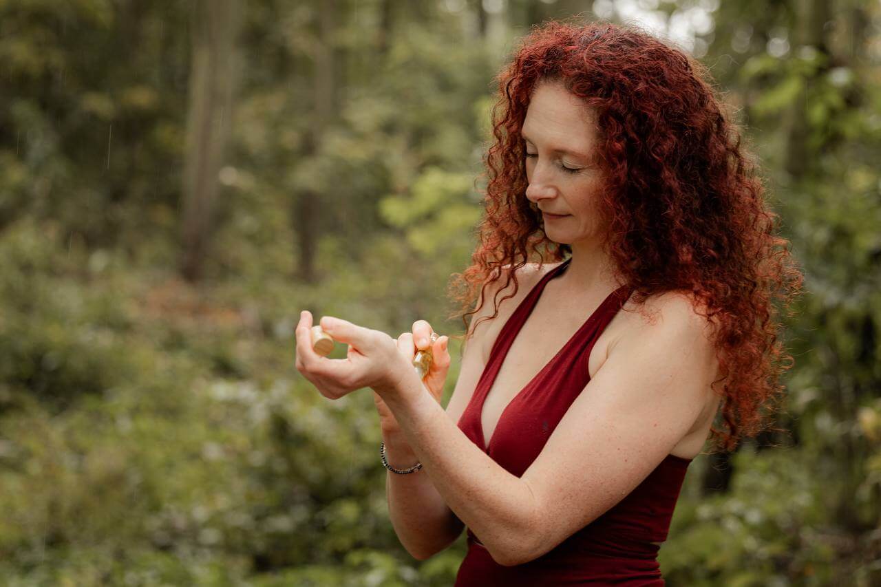 Tina Wasem, Heilhexe wie sich gerade ätherisches Öl aus ihrem Roller auf den Puls Bereich der linken Hand rollt.